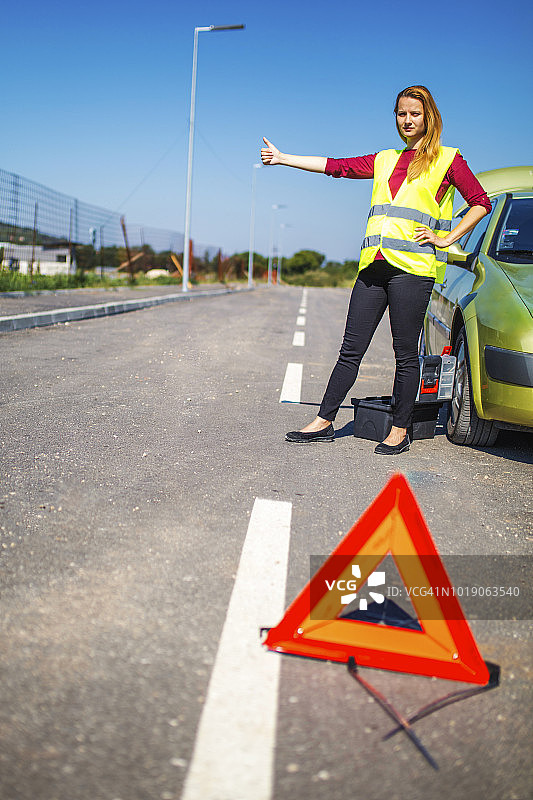 和她的抛锚汽车在一起的年轻女人图片素材