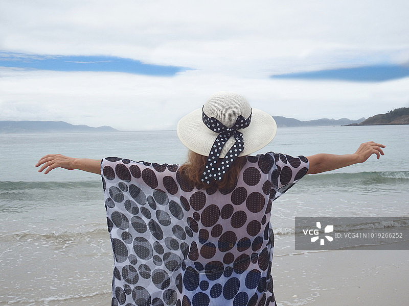 美丽的女人在西班牙蓬特韦德拉的锡耶斯群岛海滩享受阳光图片素材