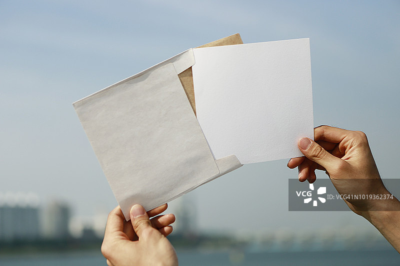 手持白色信封和卡片图片素材