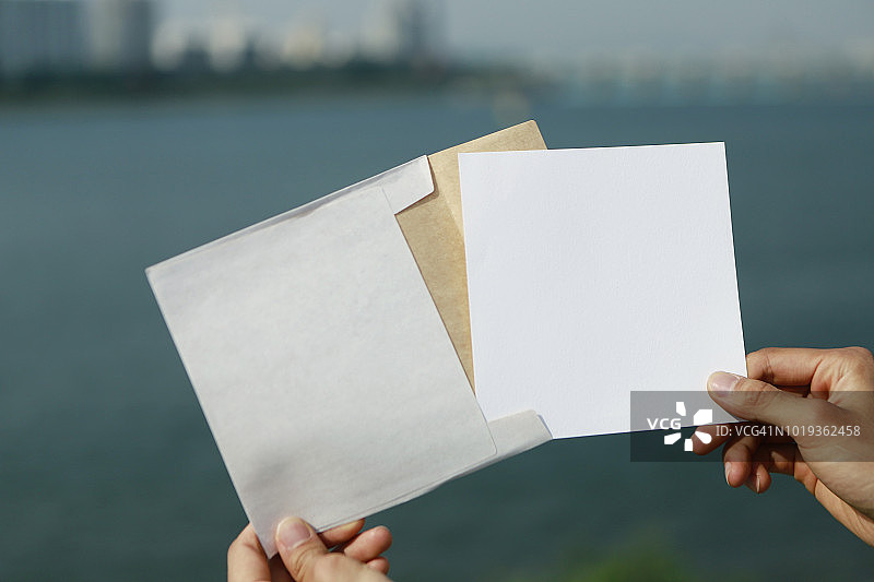 手持白色信封和卡片图片素材