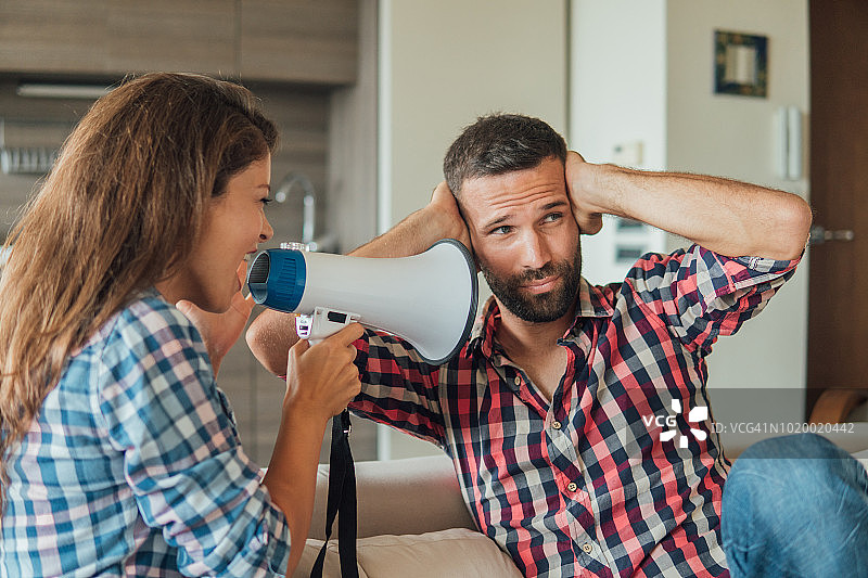 年轻女人用扩音器对男人喊话图片素材