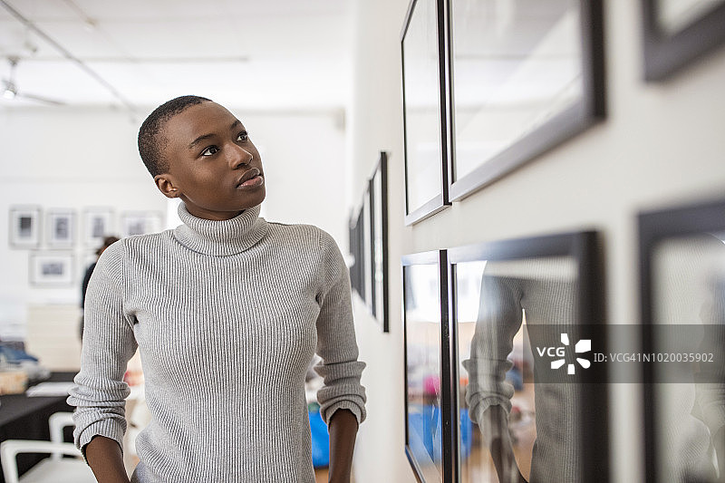 年轻女子在美术馆看画的肖像图片素材