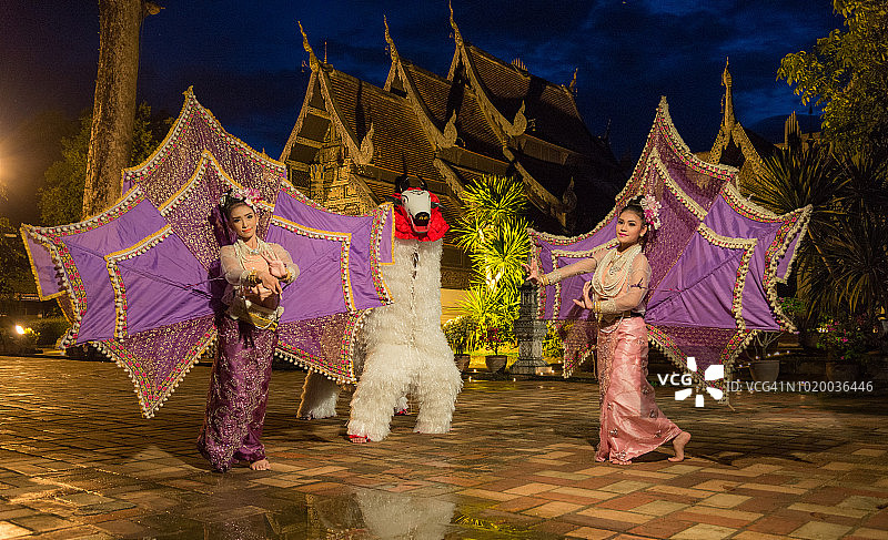两位身着泰国服装的泰国妇女表演艺术泰国文化 Ging Gala 鸟舞和 Singh(Toe)。掸(泰)族在泰国清迈 Chedi-luang 寺庙为佛陀举行的舞蹈传统仪式。图片素材
