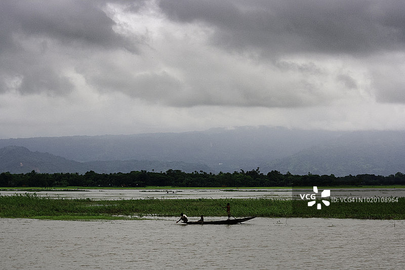 渔民在唐古尔沼泽（孟加拉国苏纳姆甘杰）的划艇上寻找鱼图片素材