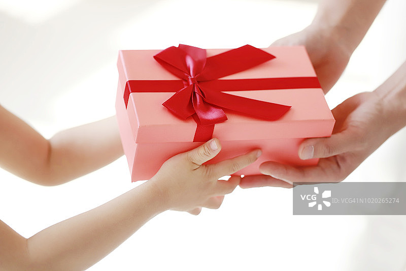 女婴和母亲拿着礼品盒的特写图片素材