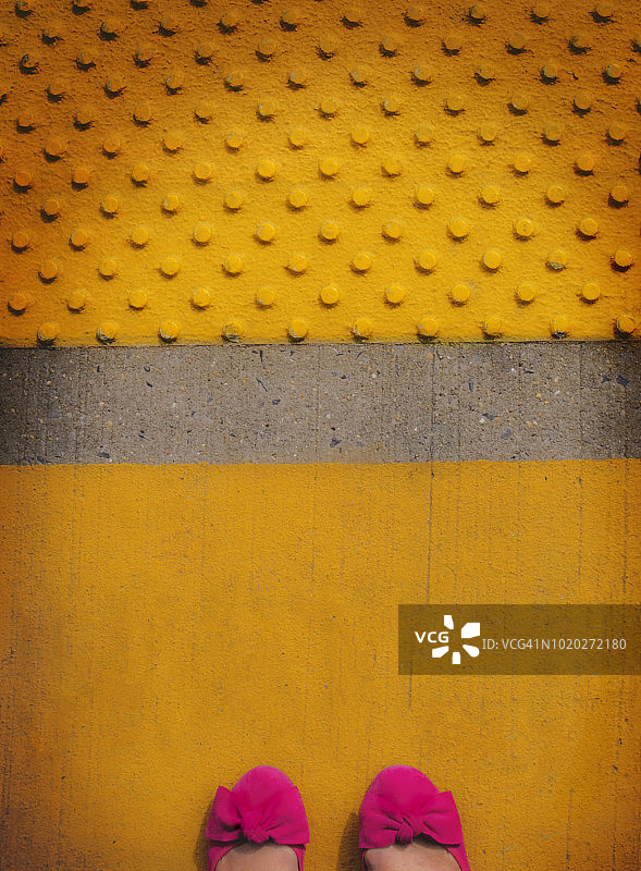 通勤者在黄色火车站台上穿着粉色鞋子图片素材