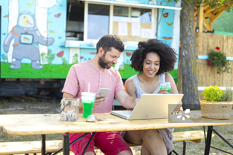 游客在户外饮用绿色鸡尾酒图片素材