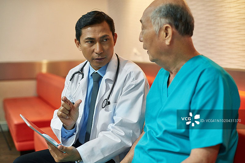 医生用平板电脑向病人解释报告图片素材