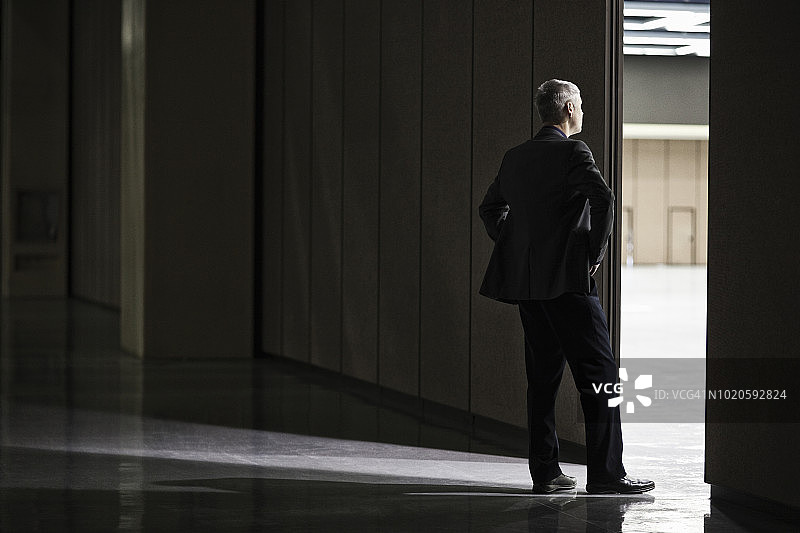 商人站在会议中心竞技场房间之间的门口图片素材