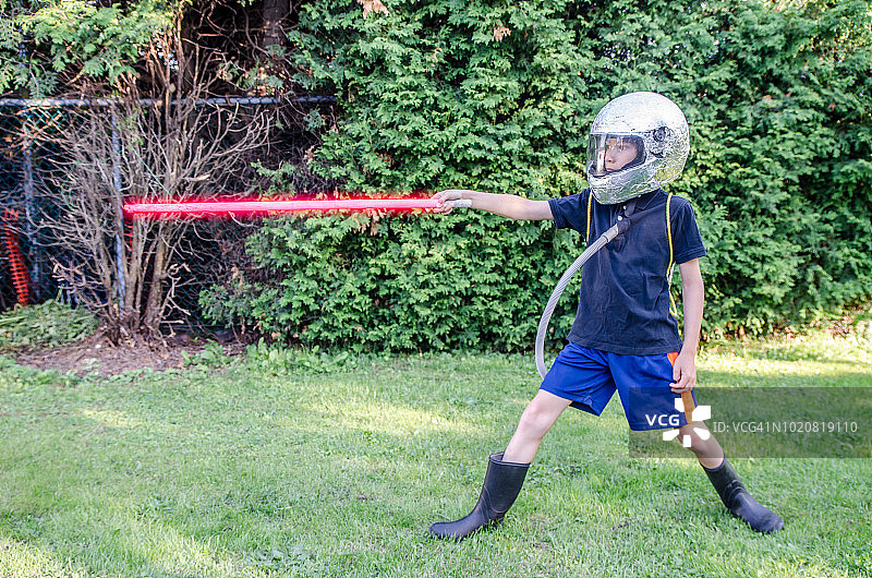 夏天，后院里装扮成宇航员的年轻男孩图片素材