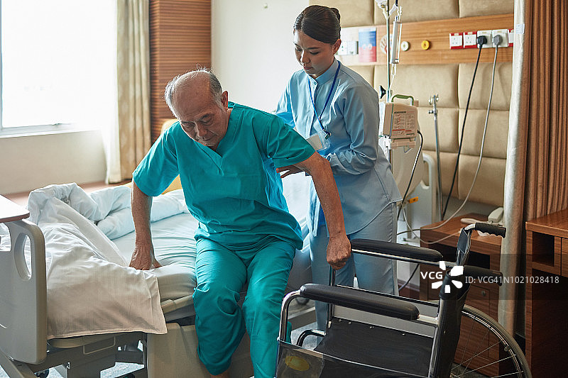 护士帮助病人坐在病床上图片素材