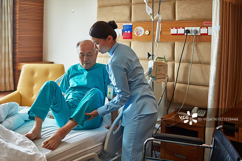 护士在病床上帮助老年病人图片素材