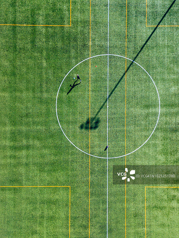 绿茵足球场上的孤单足球运动员（俯视）图片素材