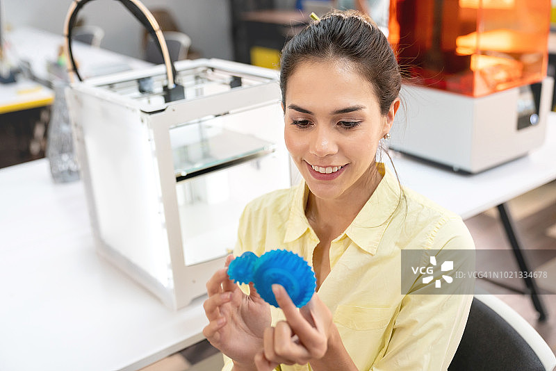 快乐的设计师使用3D打印机图片素材