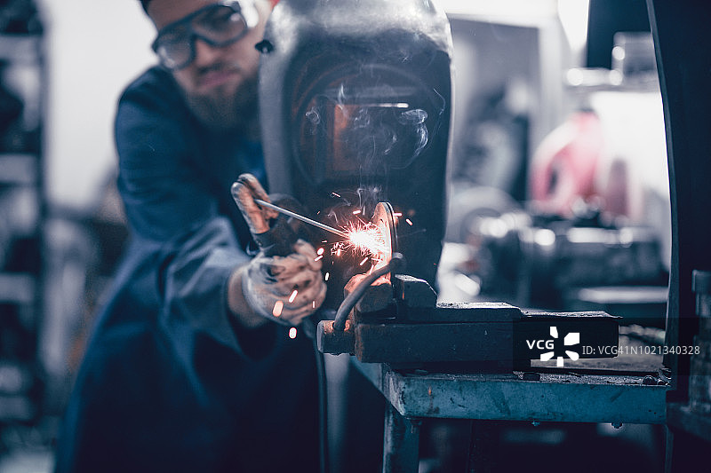 男焊工在车间修理更换零件图片素材
