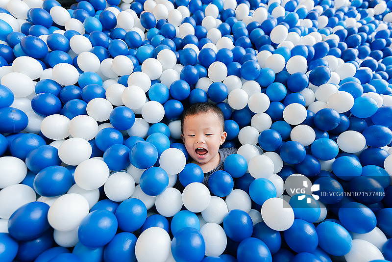 在球池里快乐玩耍的可爱小男孩图片素材