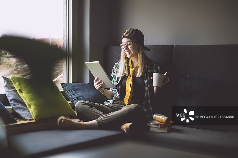 年轻女人在舒适的角落里休息图片素材