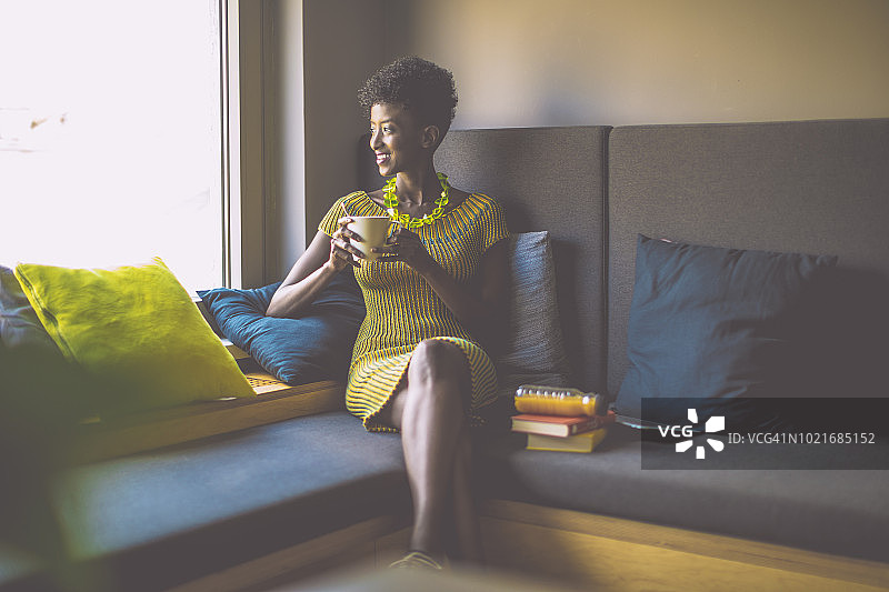 年轻女人在舒适的角落里休息图片素材