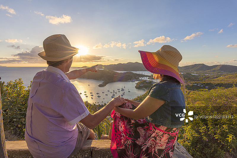 在安提瓜雪莉高地山丘上眺望海湾和英国港的相爱男人和女人图片素材