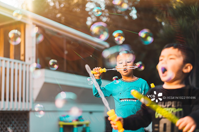 在后院吹泡泡的两名混血儿童图片素材