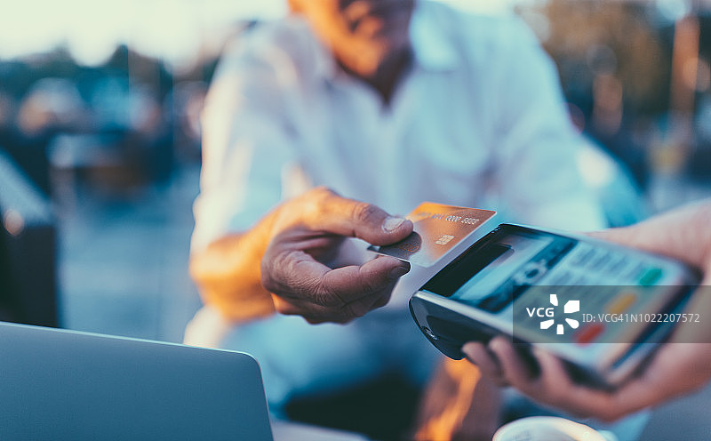 在咖啡馆使用非接触式支付的年长男人图片素材