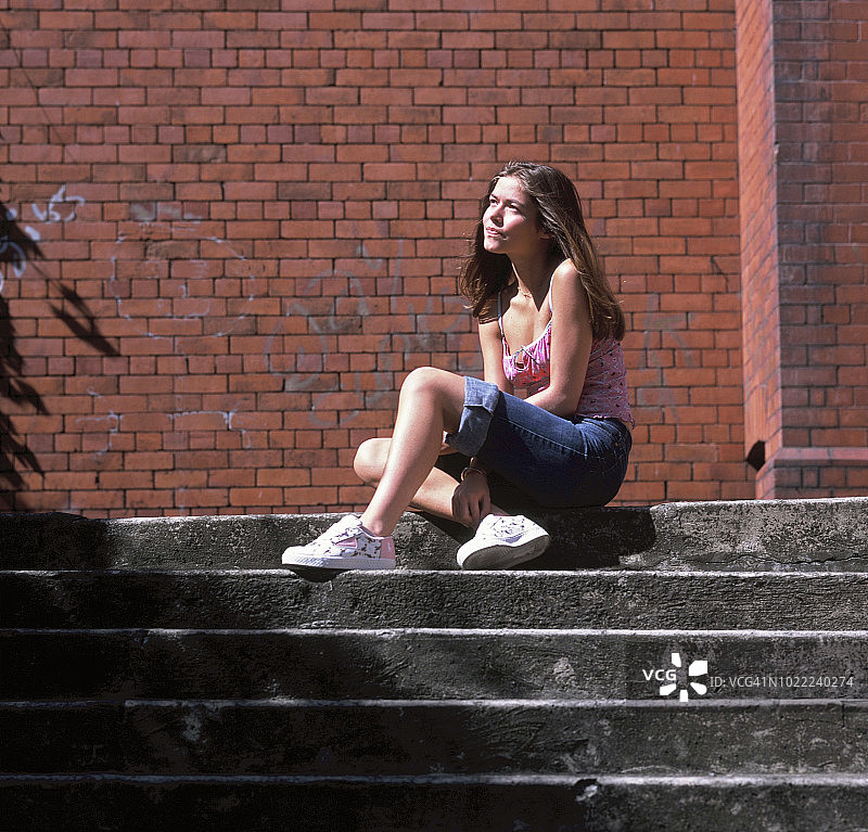 少女坐在户外台阶上沉思图片素材