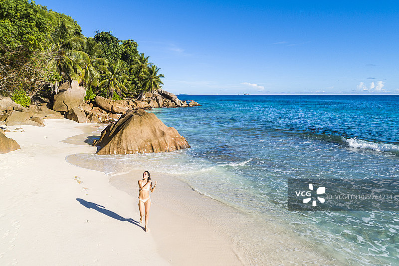 年轻女人在热带海滩上享受阳光图片素材