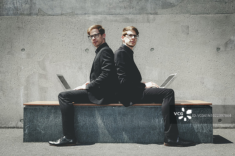 肩并肩工作的双胞胎兄弟图片素材