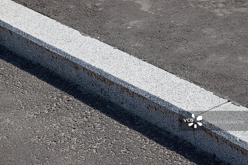 白色路缘石边界和沥青路图片素材