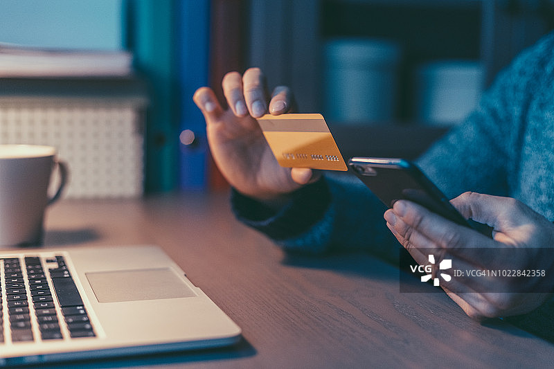 男人使用信用卡和智能手机在线预订图片素材