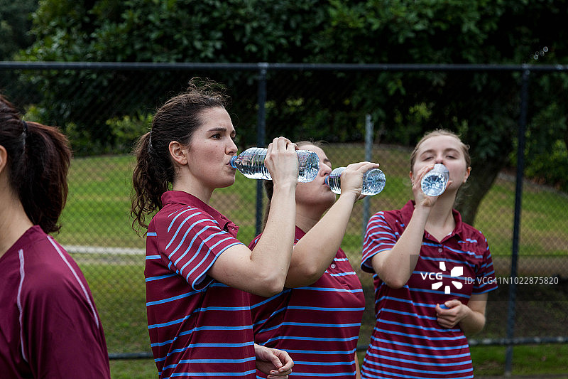 成年女足球员在训练时喝水图片素材