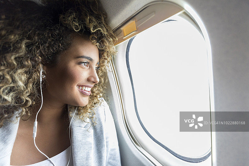 女人在飞机上看窗外图片素材