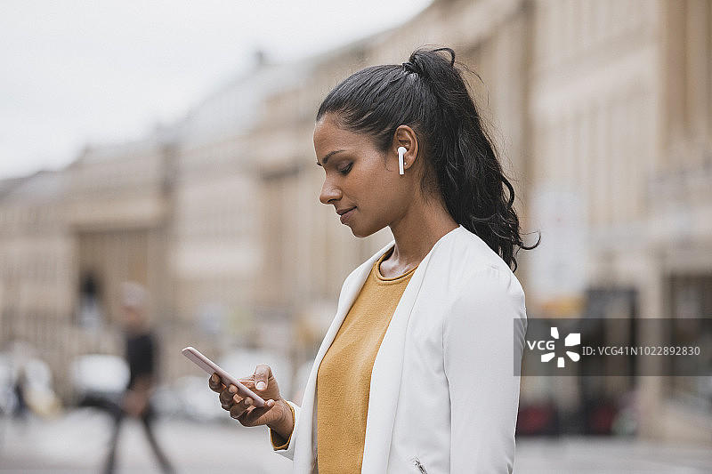站在纽卡斯尔泰恩河畔灰色街道上的女商人图片素材