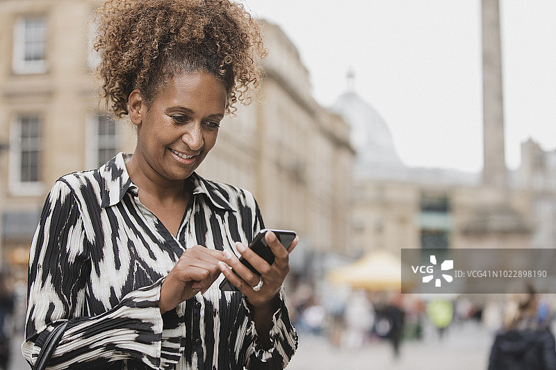 在纽卡斯尔市中心使用智能手机的女商人图片素材