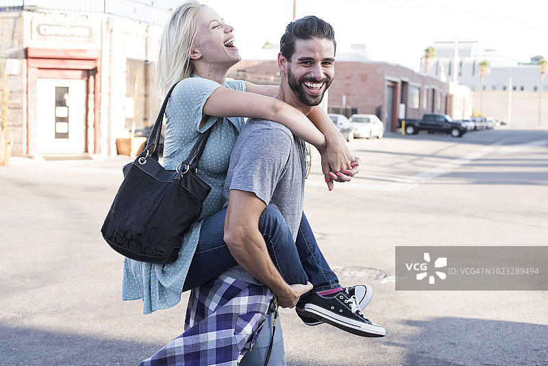 背着女友的快乐年轻人图片素材