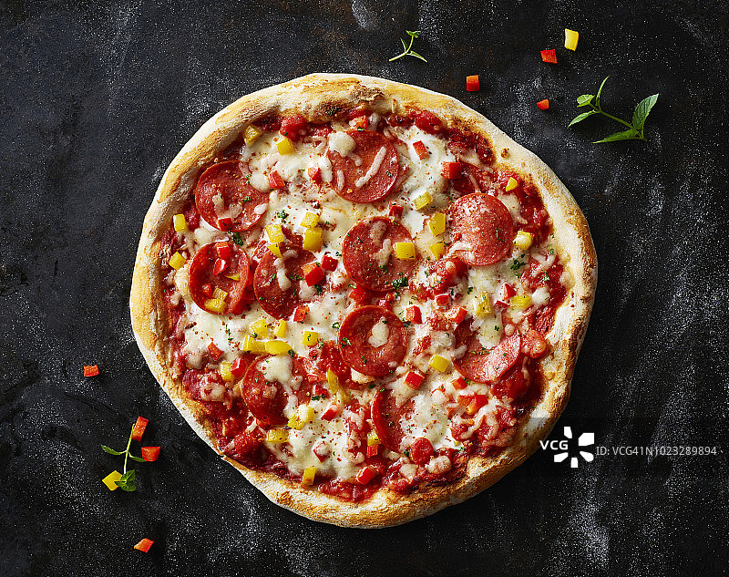 深色背景上的萨拉米香肠披萨图片素材