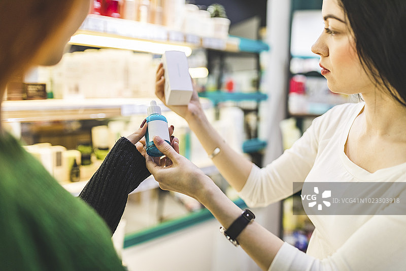 两位女士在化妆品店试用产品图片素材