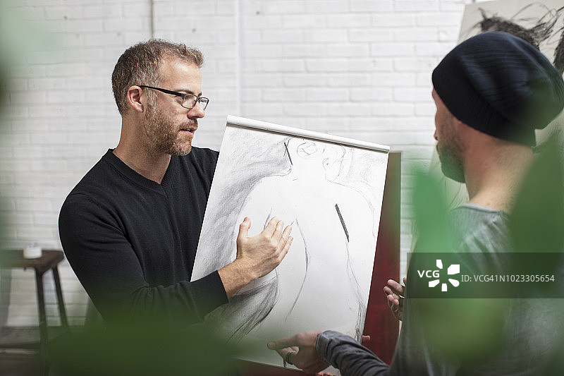 艺术家在工作室与男人讨论绘画图片素材