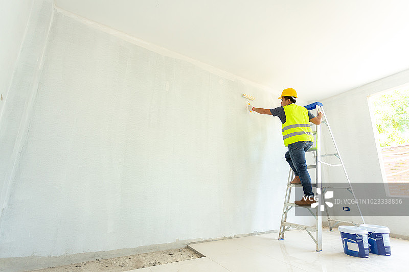 油漆工人在墙上用滚筒工作图片素材
