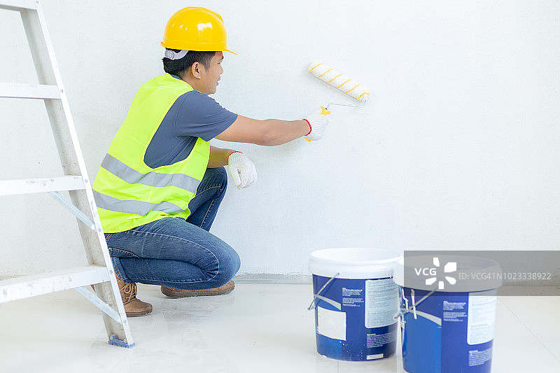 油漆工人在墙上用滚筒工作图片素材