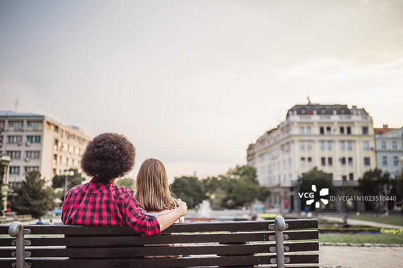 在大学公园长椅上休息的年轻情侣学生图片素材