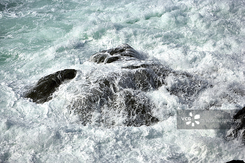 冰岛韦斯特曼群岛叙尔特塞火山岛岩石上的波浪图片素材