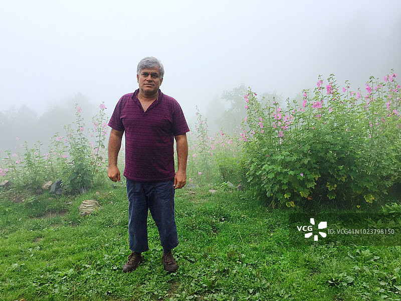 徒步旅行者在郁郁葱葱的绿地上享受雾蒙蒙的天气图片素材