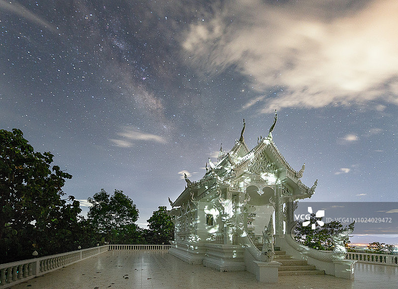 在清迈的帕拉特乔姆吉提寺，星空、云朵和银河下的白色宝塔图片素材