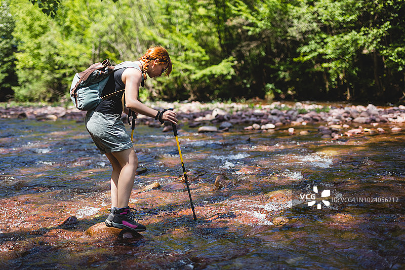 女徒步旅行者过河图片素材