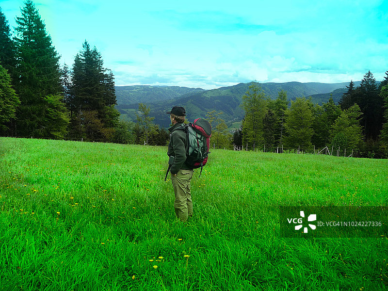 徒步旅行者，拥有葡萄园、森林、山丘的村庄景观图片素材