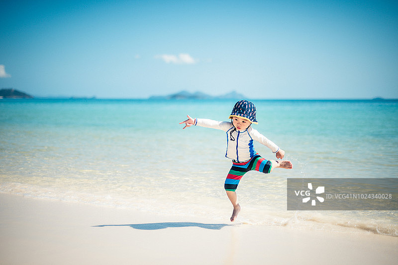 可爱的中国男孩在沙滩上玩耍图片素材