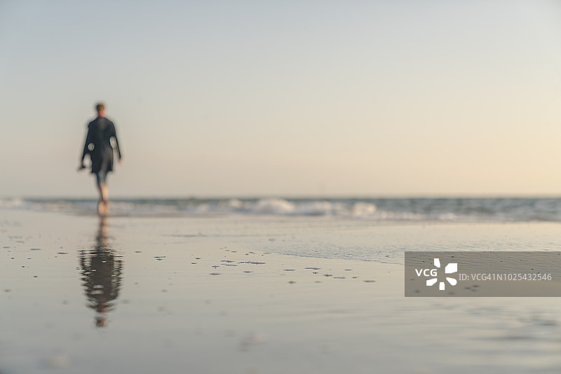 夕阳下站在海滩上的女子轮廓，叙尔特岛图片素材