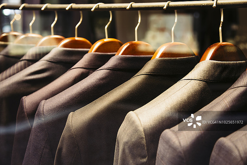 挂在架子上的男士西装特写图片素材