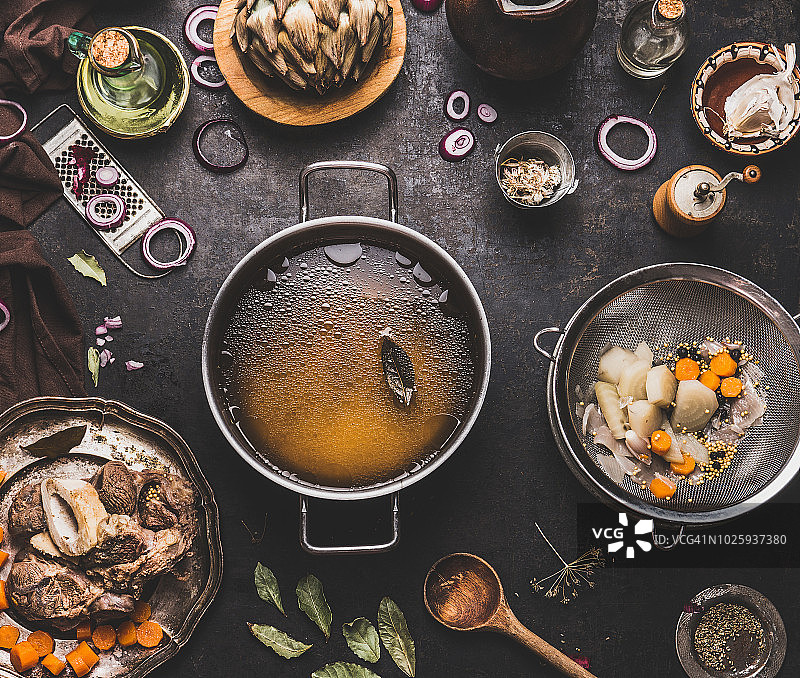 厨房餐桌上烹饪锅中无肉的清澈牛肉骨汤或高汤图片素材